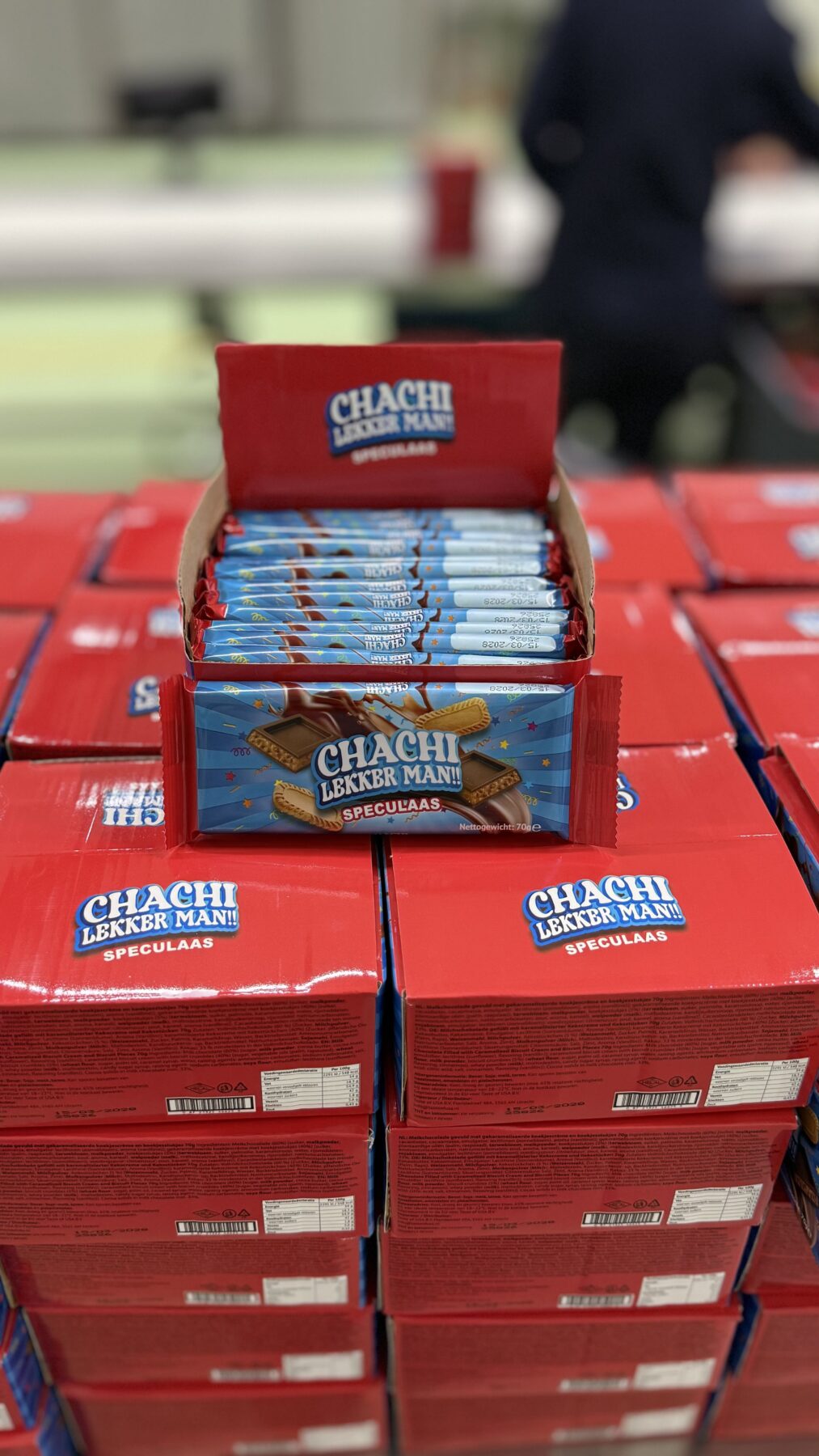 Stapels rode verkoopdozen CHACHI Speculaas, met een geopende doos vol repen bovenop.