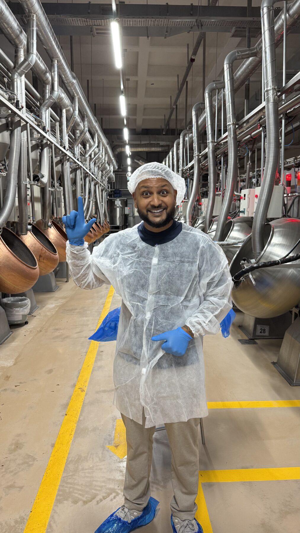Cha Chi Versaci in de fabriekshal tussen de koperen mengketels waar de chocolade wordt gemaakt.